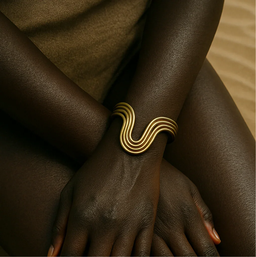 Gold bracelet on a wrist with a neutral background
