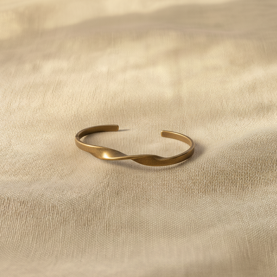 Gold bracelet on a beige fabric background