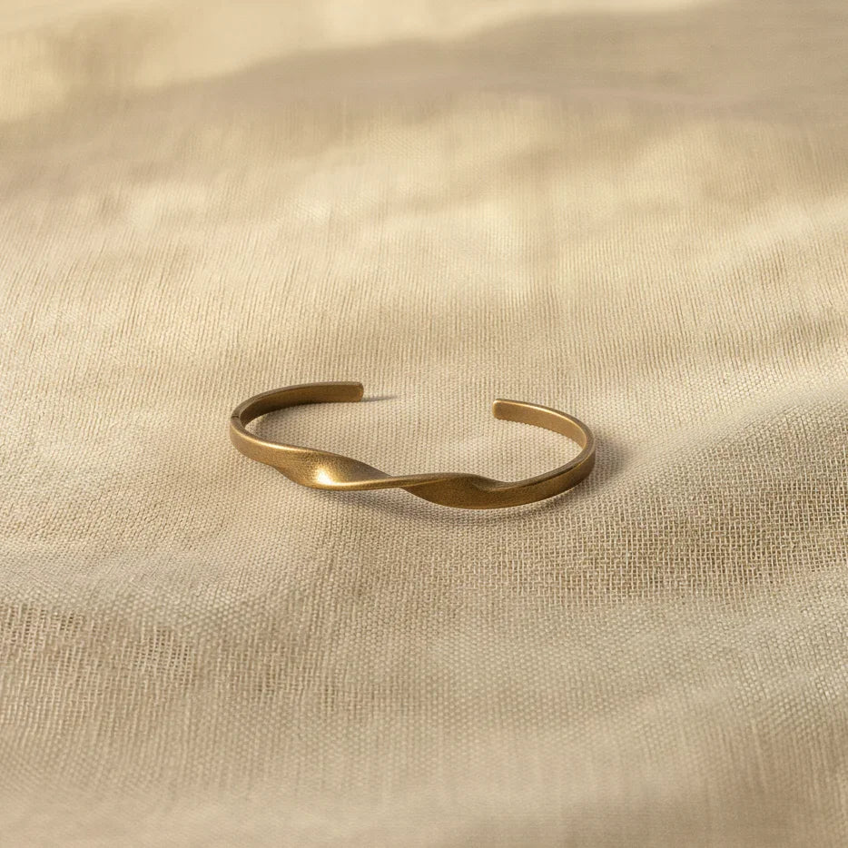 Gold bracelet on a beige fabric background