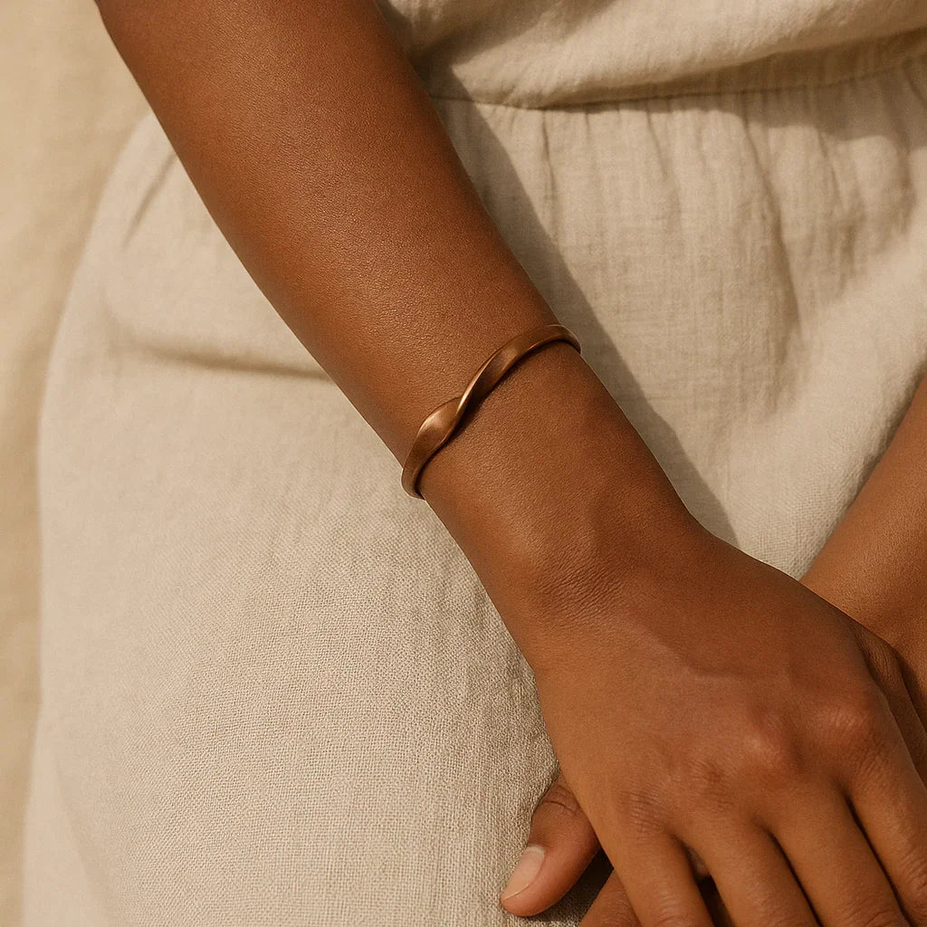 Close-up of a hand wearing a bracelet on a beige fabric background