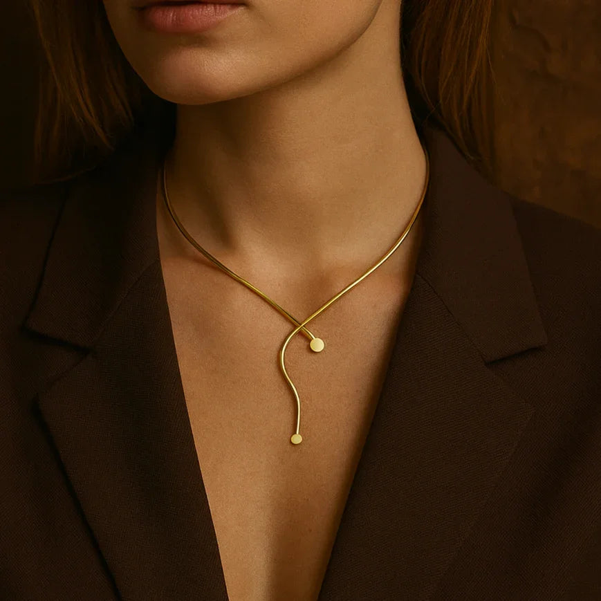 Woman wearing a gold necklace against a brown background