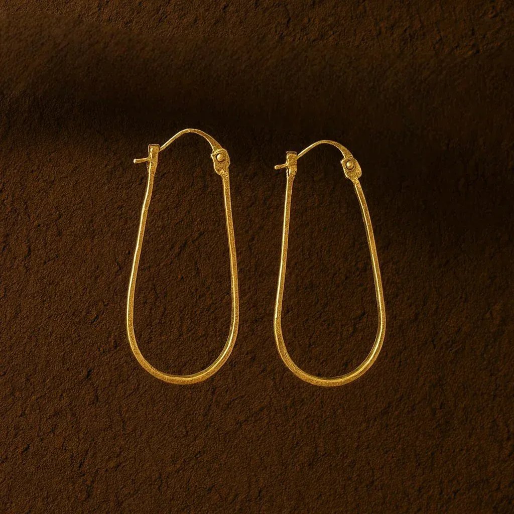 Gold hoop earrings on a brown textured background