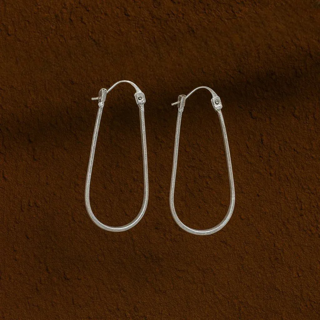 Silver hoop earrings on a brown textured background