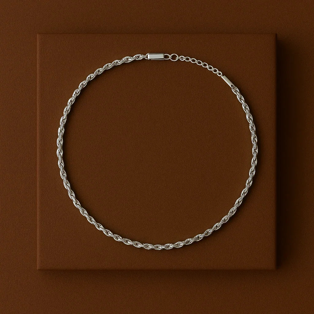 Silver chain necklace on a brown square platform with a brown background
