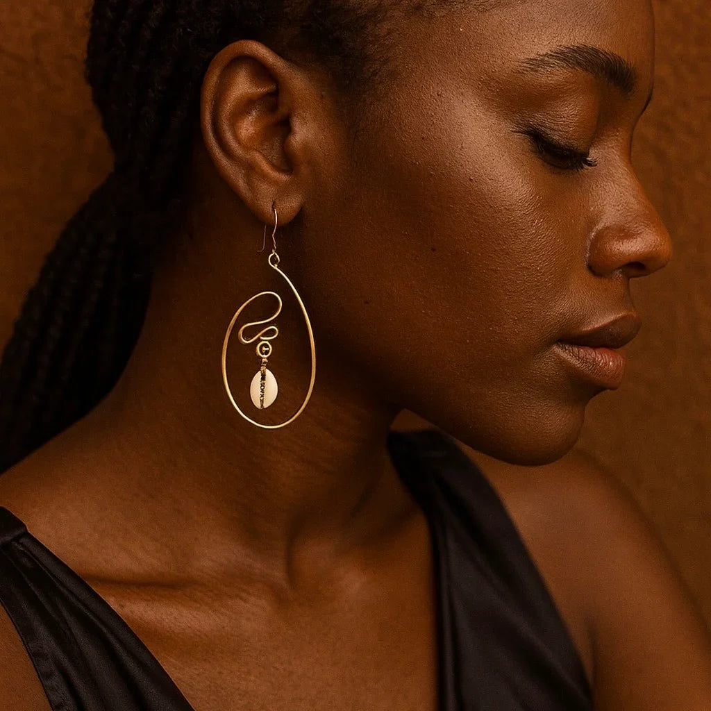 Close-up of a woman wearing a gold earring against a warm brown background