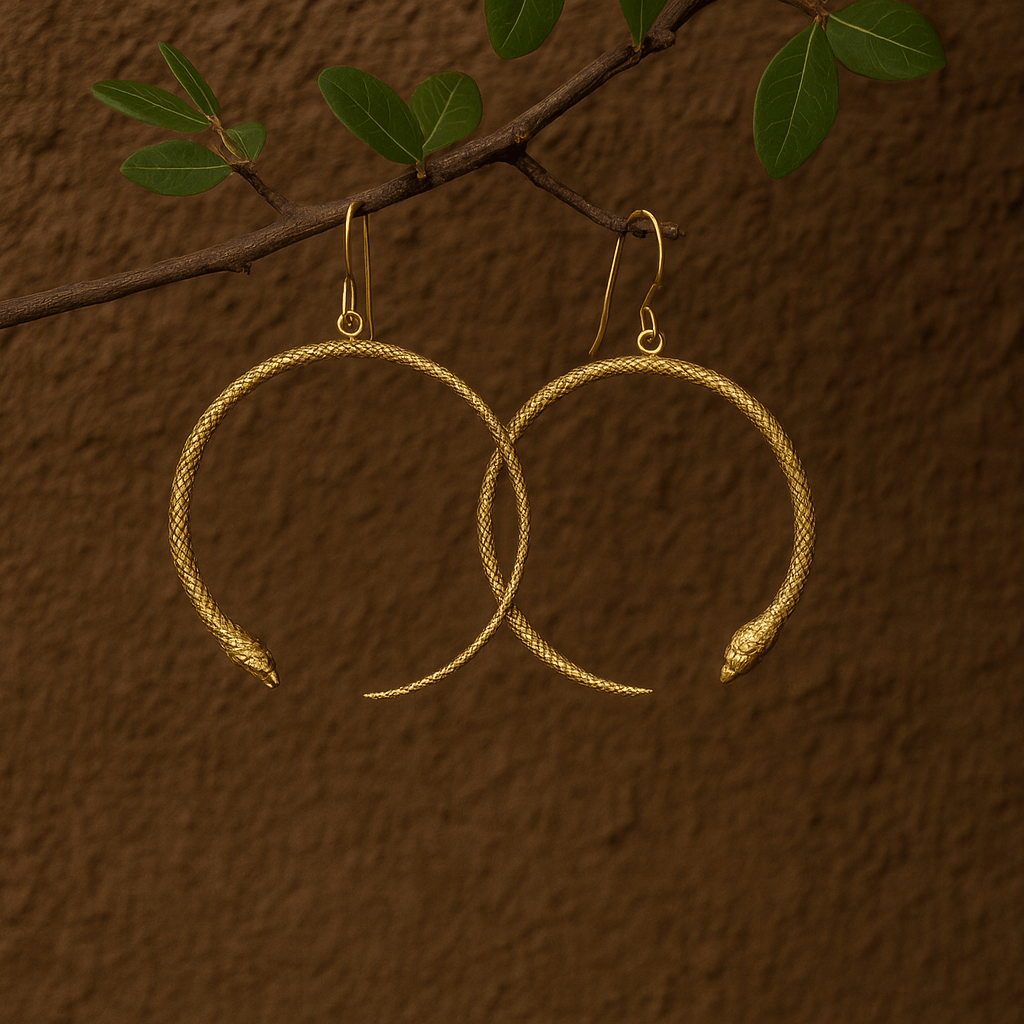 Gold hoop earrings with snake heads on a brown textured background