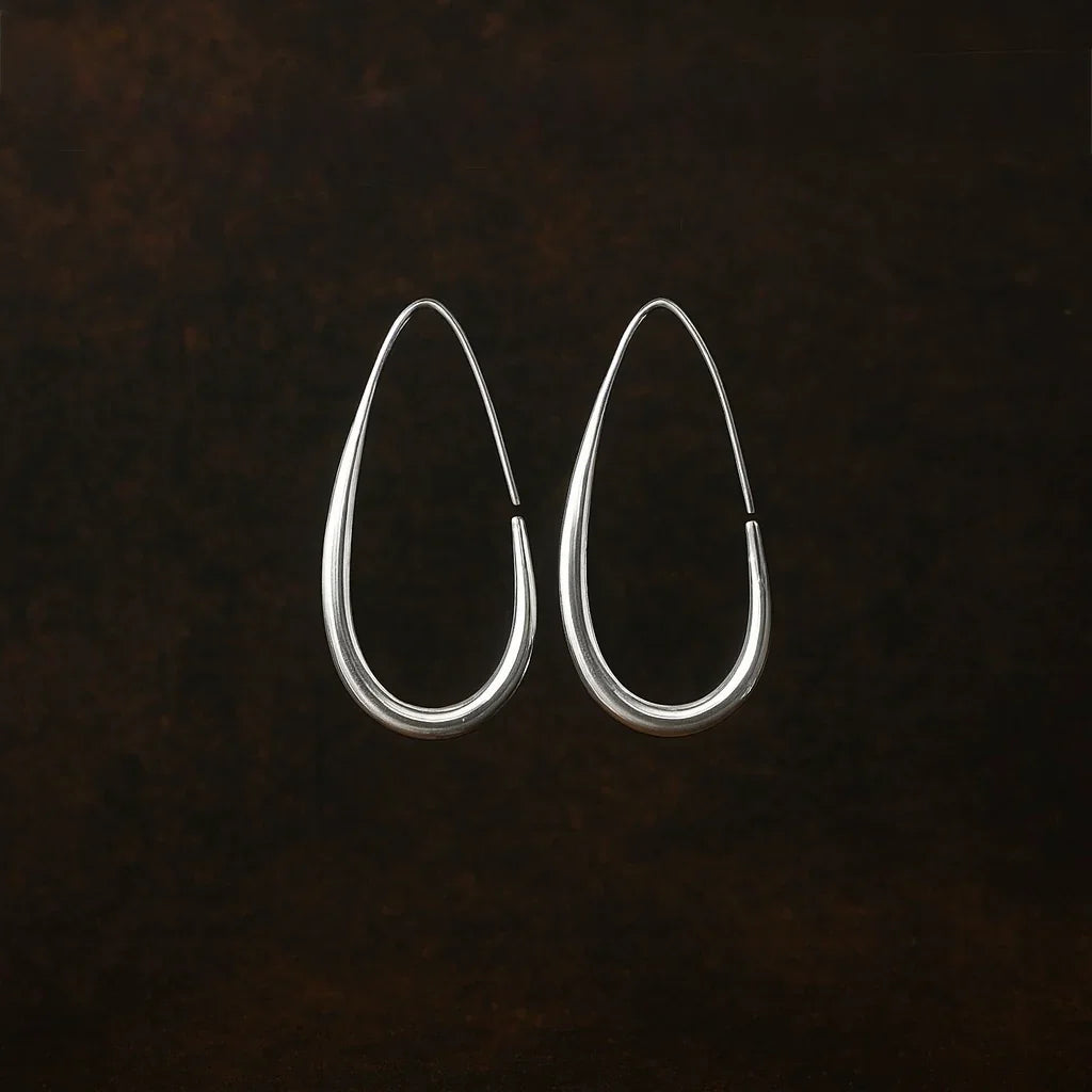 Pair of silver hoop earrings on a dark textured background