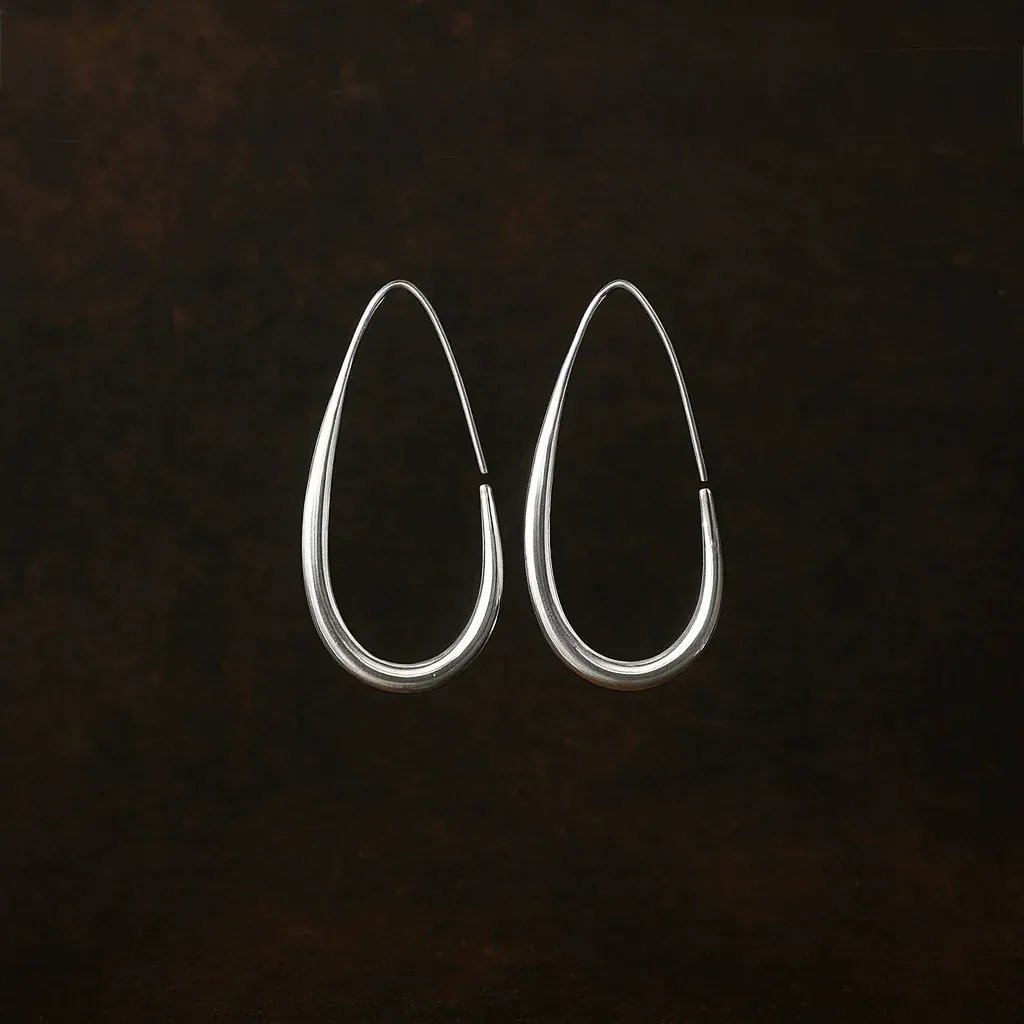 Pair of silver hoop earrings on a dark textured background