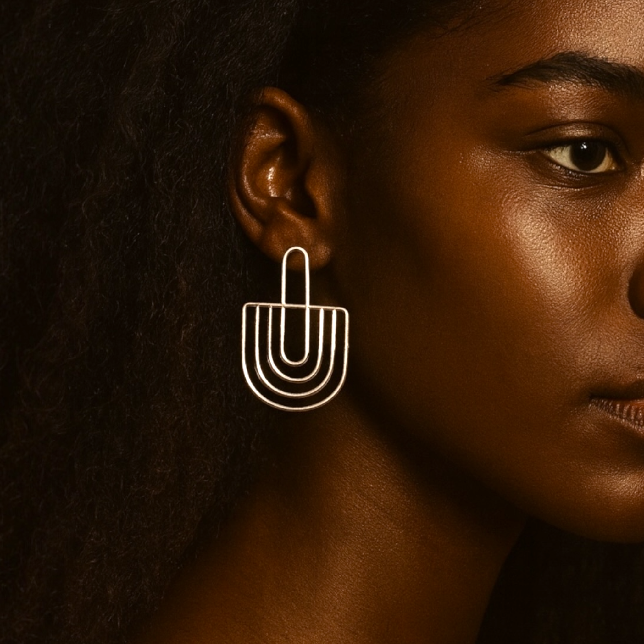 Earring worn by a model against a dark background