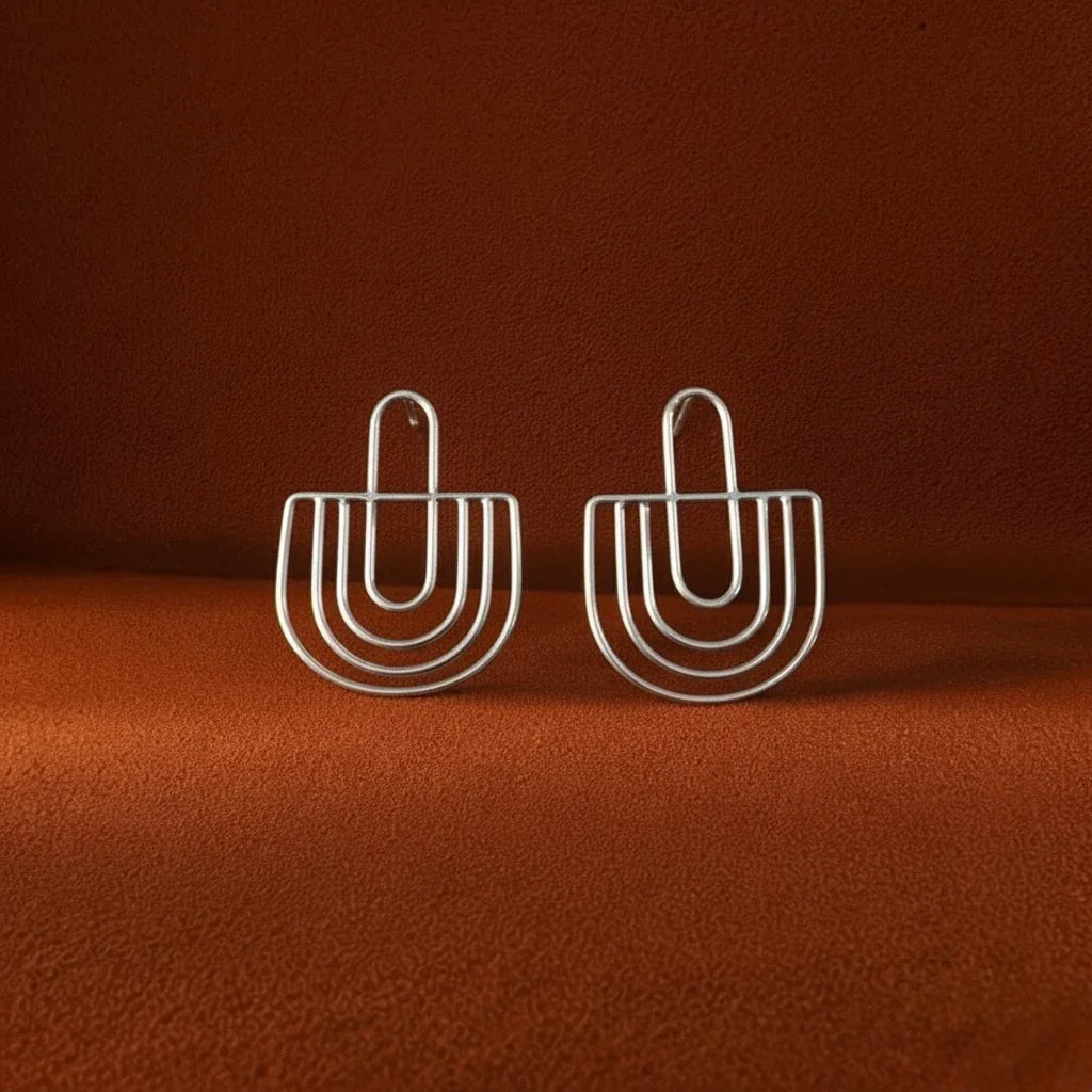 Pair of silver hoop earrings on a brown background