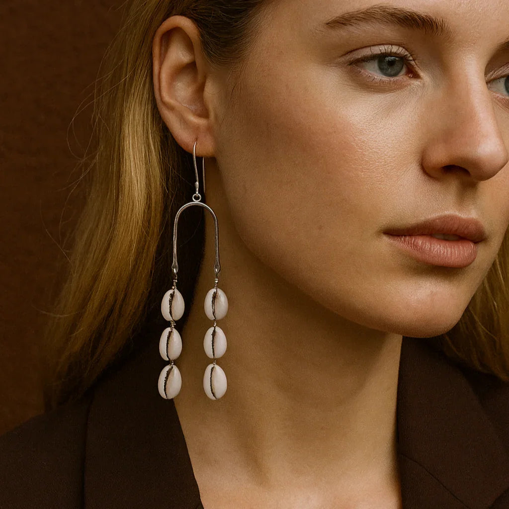 Close-up of a woman wearing elegant earrings with a brown background
