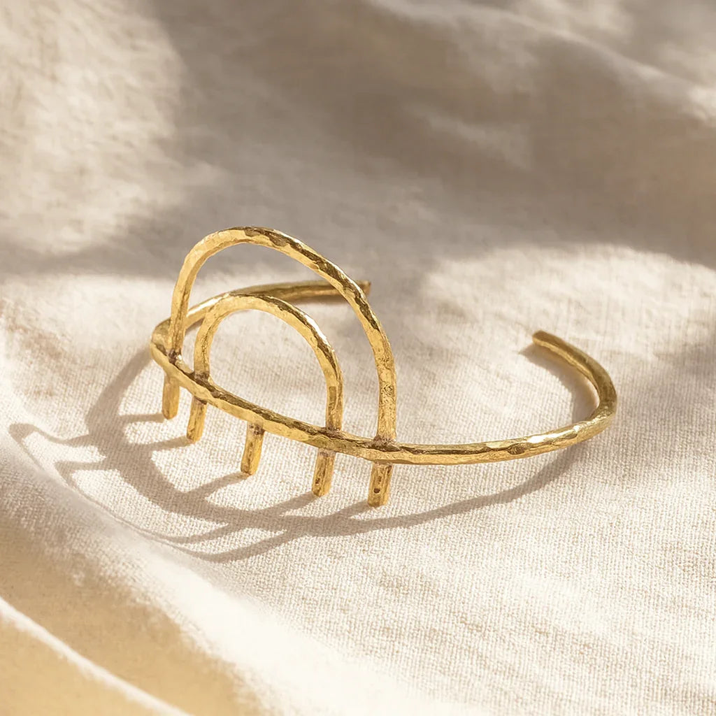 Gold bracelet on a beige fabric background