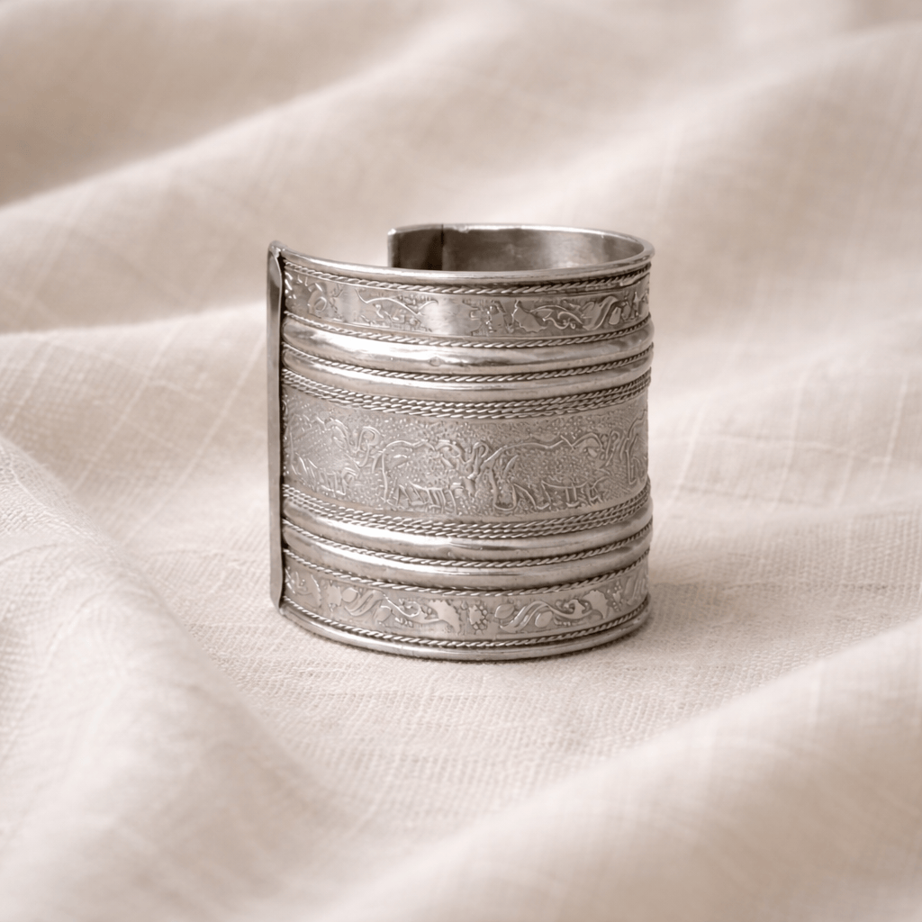 Decorative silver bracelet on a textured beige fabric background
