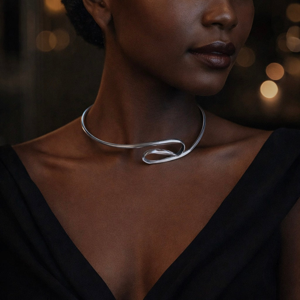 Woman wearing a silver necklace with a dark background
