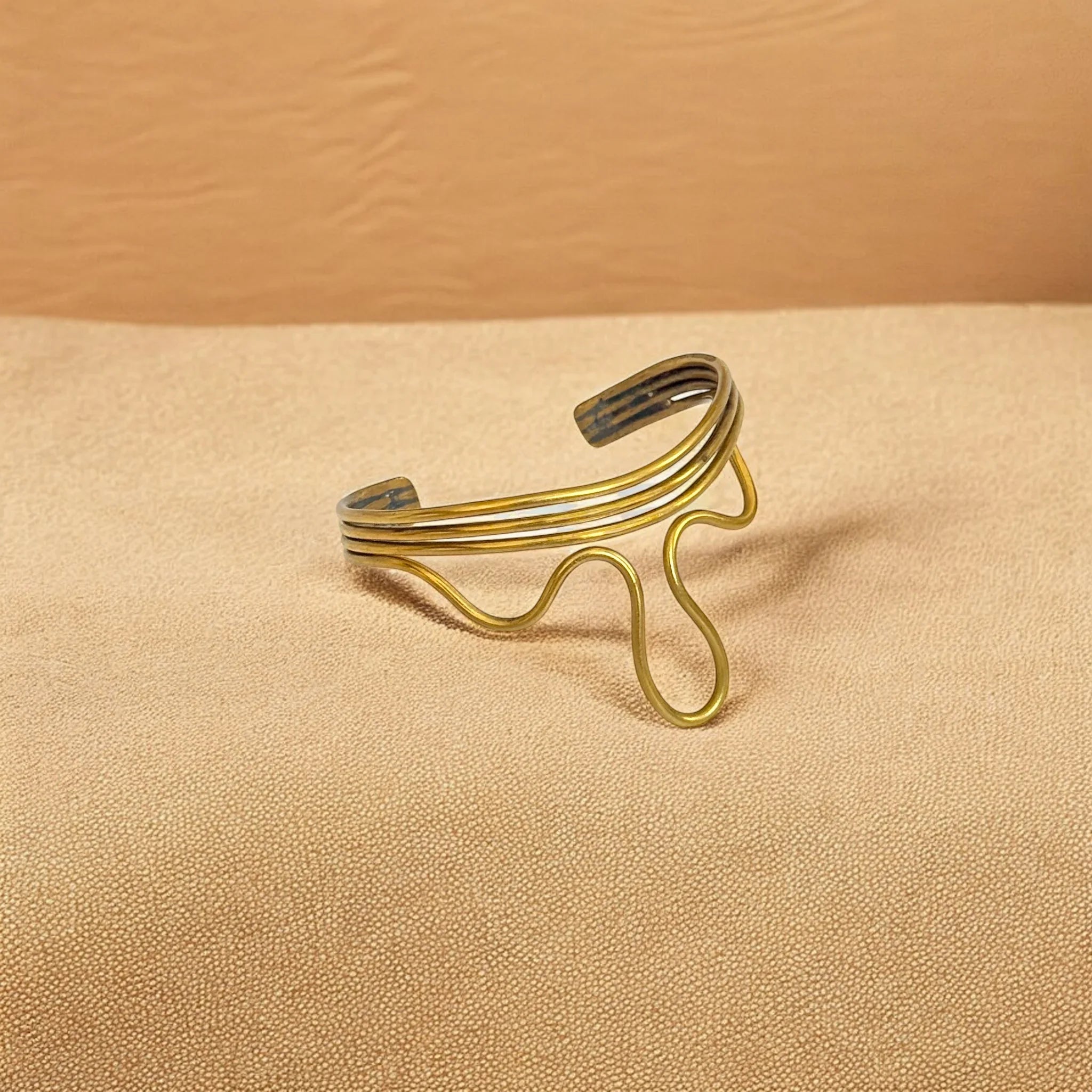 Gold bracelet on a beige background