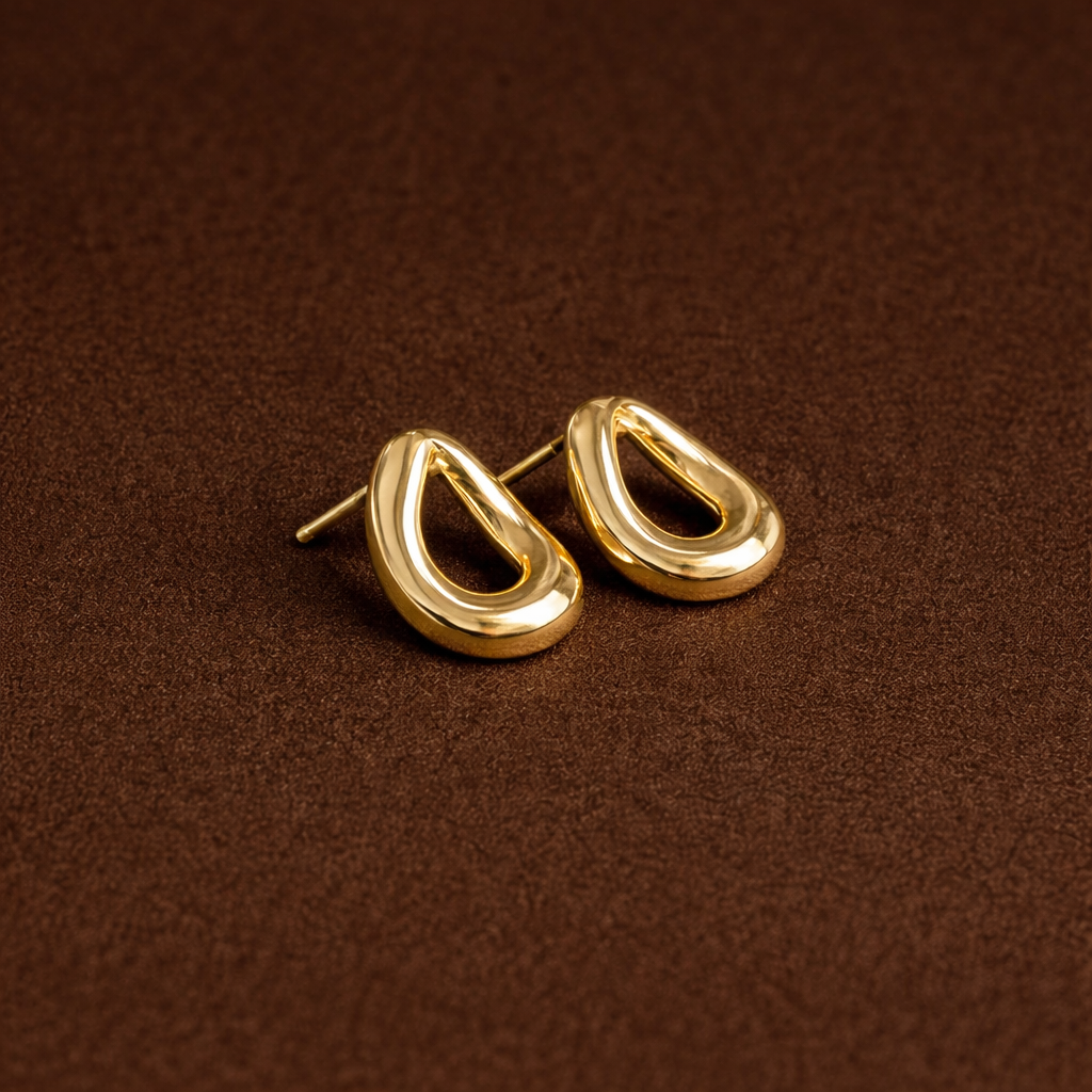 Gold hoop earrings on a brown textured background