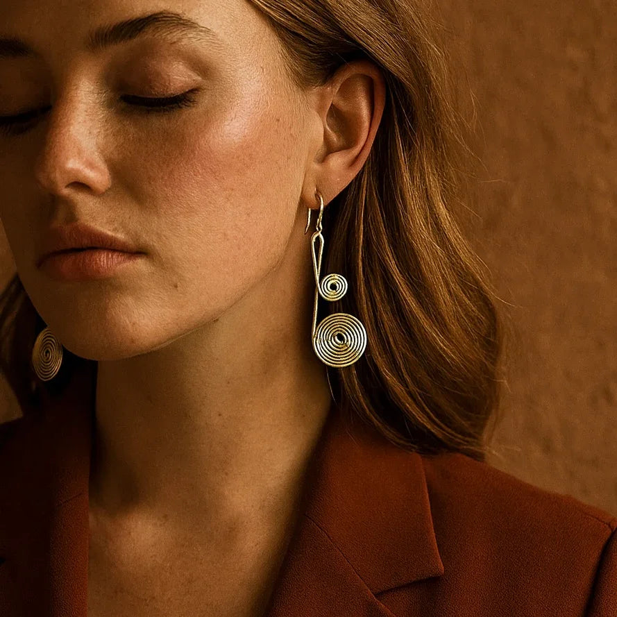 Close-up of a woman wearing gold earrings against a warm brown background