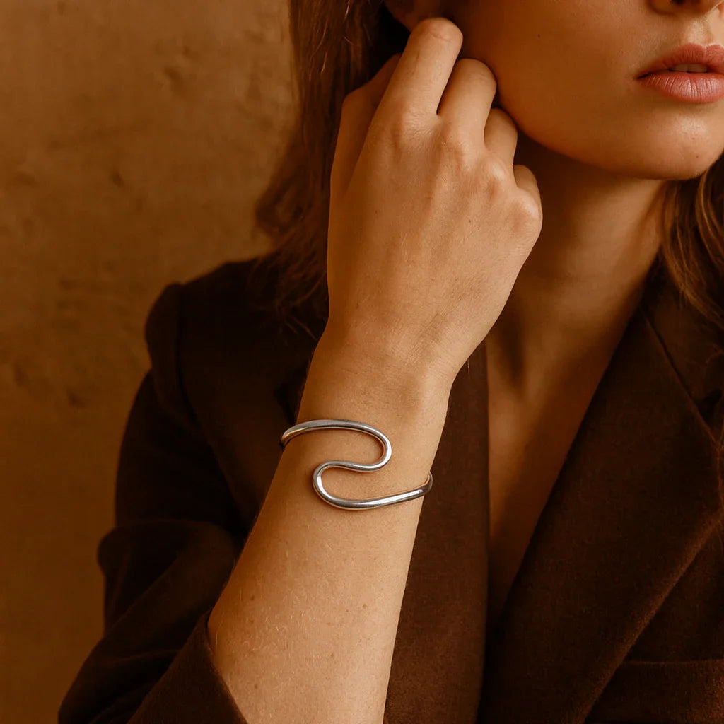 Woman wearing a silver bracelet on a brown background