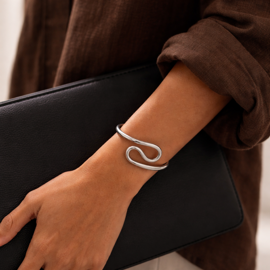 Person wearing a silver bracelet on a blurred background