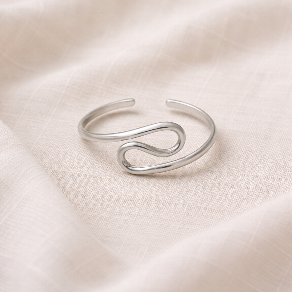 Silver ring with a unique design on a beige fabric background