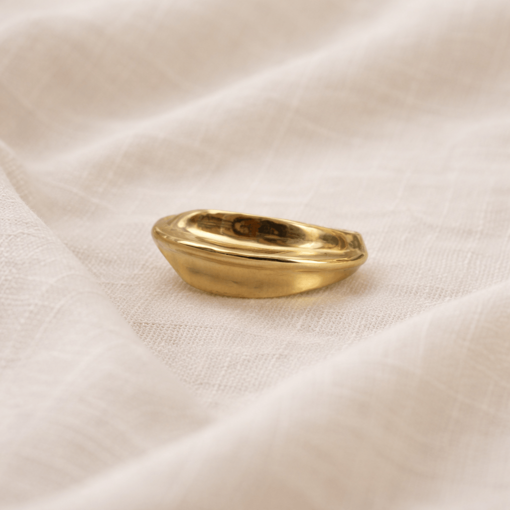 Gold ring on a textured beige fabric background