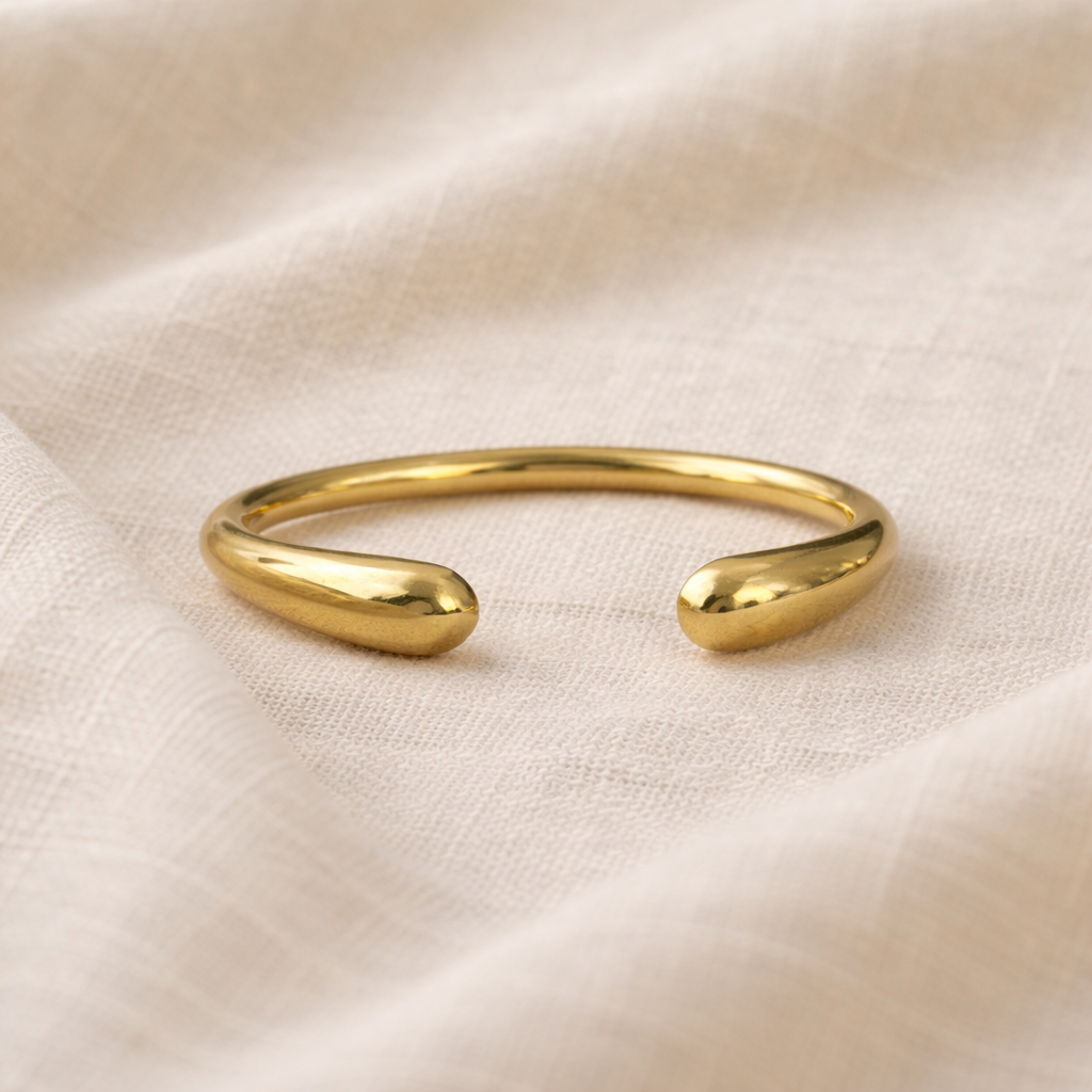 Gold bracelet on a beige fabric background