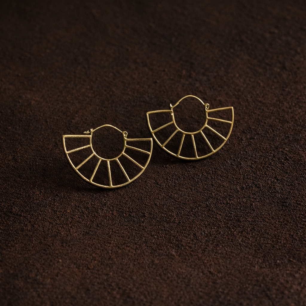 Gold hoop earrings on a brown textured surface
