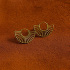 Gold hoop earrings on a textured brown surface