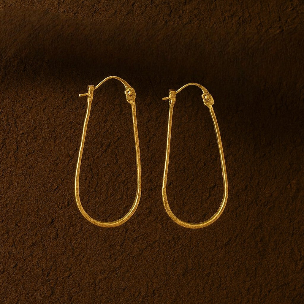 Gold hoop earrings on a brown textured background