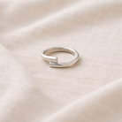 Silver ring on a beige fabric background
