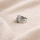 Silver ring on a beige fabric background