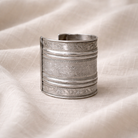 Decorative silver bracelet on a textured beige fabric background