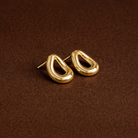 Gold hoop earrings on a brown textured background