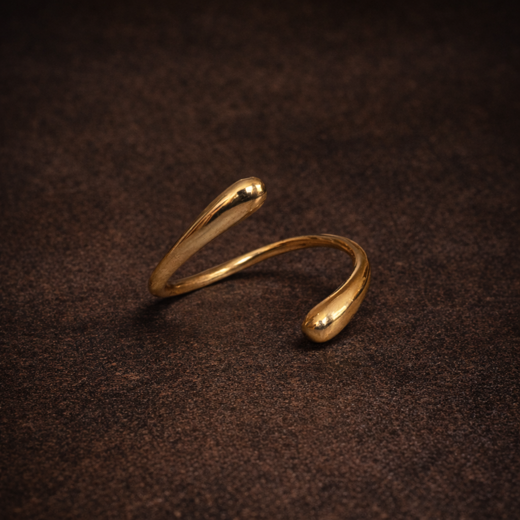 Gold open ring on a dark brown textured surface