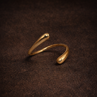 Gold open ring on a dark brown textured surface