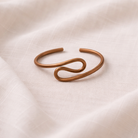 Bronze bracelet on a beige fabric background