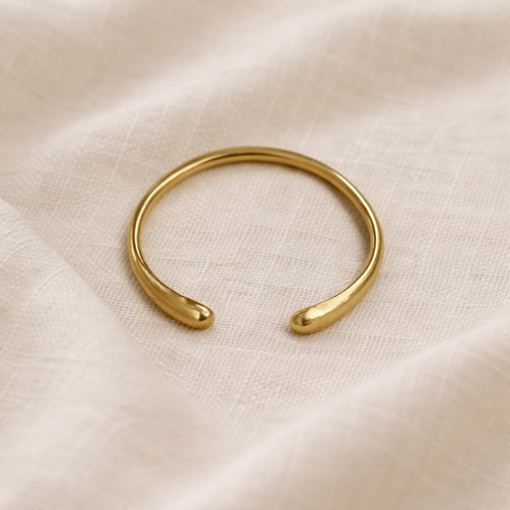 Gold bracelet on a beige fabric background