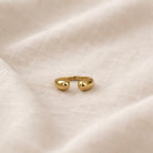 Gold ring on a textured beige fabric background