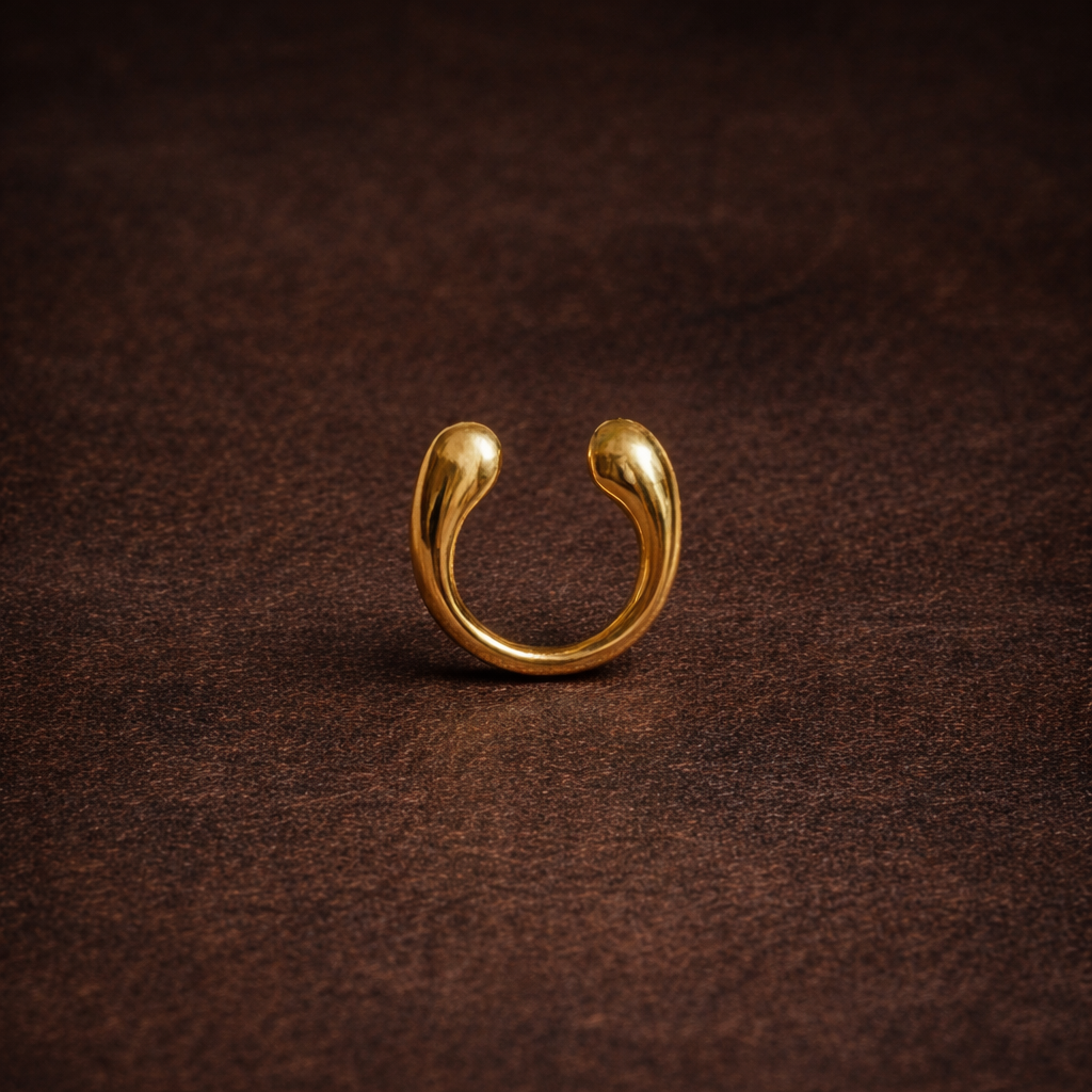 Gold earring on a brown textured background