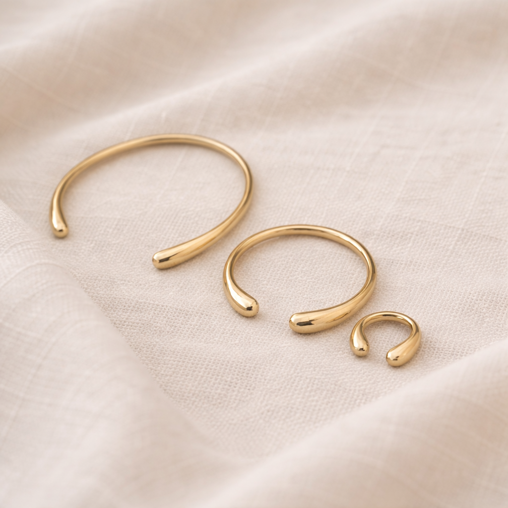 Set of gold hoop earrings on a beige fabric background