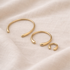 Set of gold hoop earrings on a beige fabric background