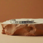 Ceramic dish with geometric pattern on a stone surface against a warm brown background