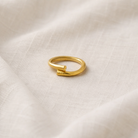Gold ring on a textured beige fabric background