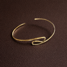 Gold bracelet on a brown textured background